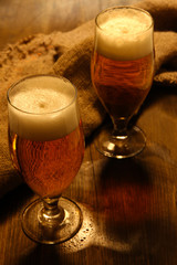 Glasses of beer on wooden table close-up