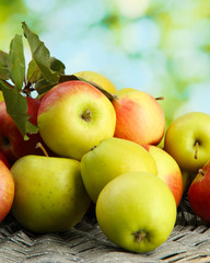 juicy apples with leaves, on green background