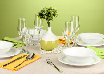Table setting in green and yellow tones on color  background