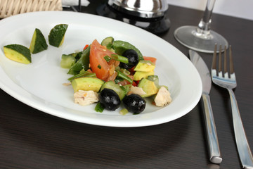 Tasty avocado salad in bowl  on wooden table close-up