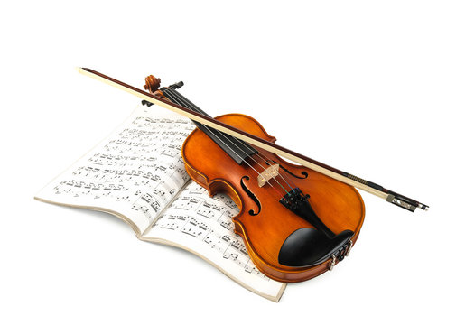Violin and fiddle stick over score isolated on white