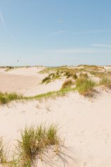 Sand dunes near the beach with blue sky.