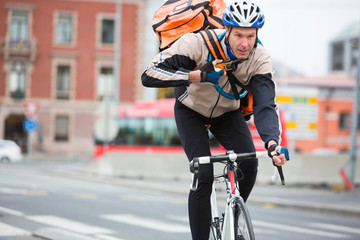 Male Cyclist With Courier Delivery Bag Riding Bicycle
