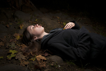 Attractive woman lying in autumn leaves