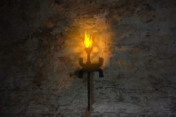 torch on the wall of an old castle