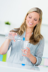 junge frau schenkt ein glas wasser ein