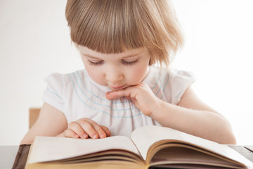 Pretty little girl reading a book