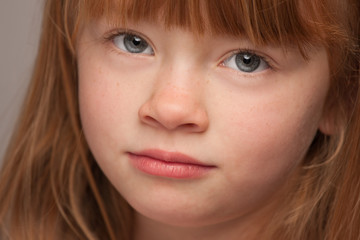 Fun Portrait of an Adorable Red Haired Girl on Grey