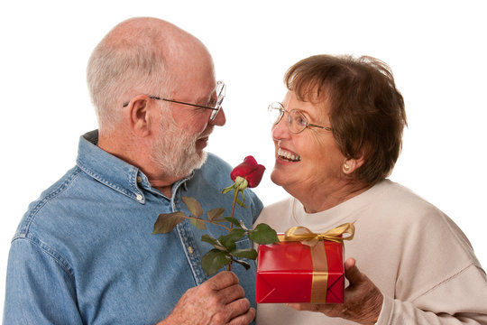 Happy Senior Couple With Gift And Red Rose