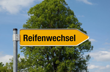 Fototapeta premium Pfeil mit Baum REIFENWECHSEL