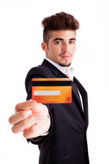 young business man holding a credit card, isolated on white