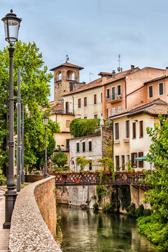 Piovego Canal with pedestrian bridge and medieval belltower in the historic center of Padua, Veneto, Italy