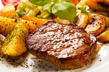 Grilled steak, baked potatoes and vegetables