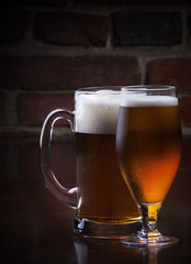 Glass of light beer on a dark pub.