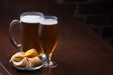 Glass of light beer on a dark pub.