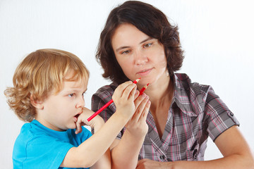 Young mother teaches her child to draw with pencils