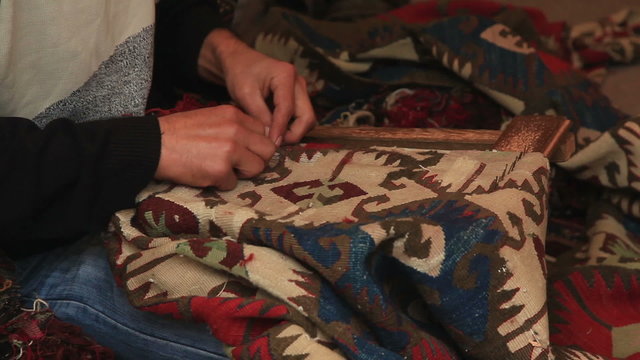Man  weaving a carpet