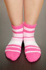 Legs female in striped socks on laminate floor