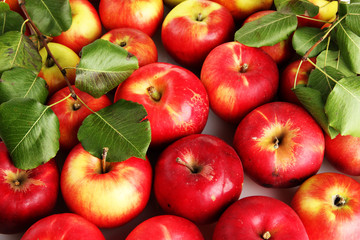 juicy red apples with green leaves, close up