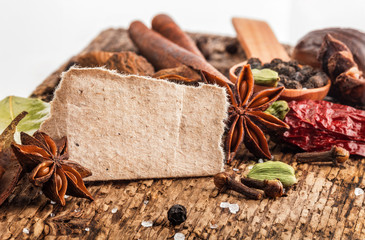 Spices on wooden table with spoons with paper for notes