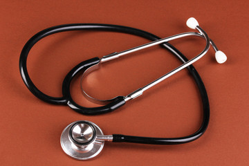Stethoscope on brown background