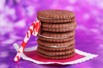 Chocolate cookies with creamy layer on purple background