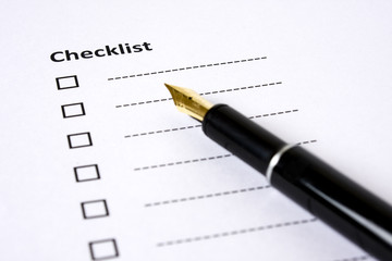 Checklist with a fountain pen on the side on a white background.