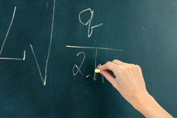 Physics formula written on blackboard with chalk.