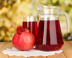 Full glass and jug of pomegranate juice and pomegranate