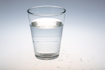 stilles Wasser im Glas vor grauem Hintergrund