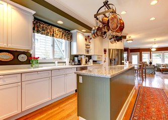 Large white and green kitchen with hardwood floor.