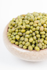 Green mung beans in bowl on white background