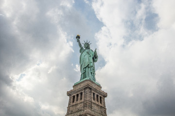 Obraz premium Statue of Liberty against bright sky with clouds