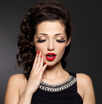 Young pretty woman with red manicure and  lips