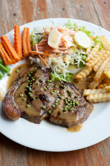 Grilled steaks with Pepper sauce, French fries and vegetables