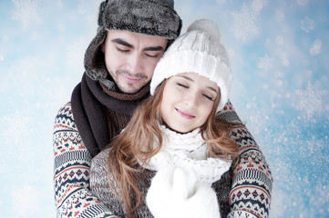 Happy young couple   covering  snow background