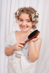 Beautiful little girl with curlers on her head