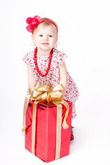 Beautiful little girl playing with a box of gift