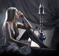 Obraz na płótnie Canvas Młodych blond kobieta w bieli¼nie palenia fajki