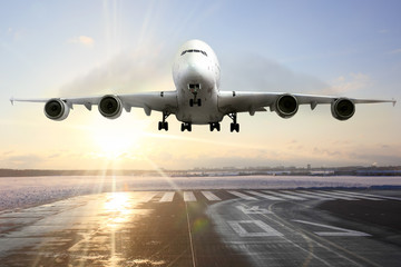 Passenger airplane landing on runway in airport. Evening