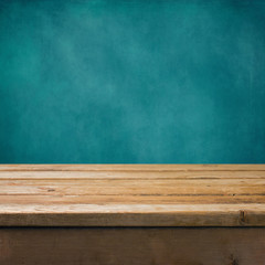 Background with wooden table and grunge blue wall