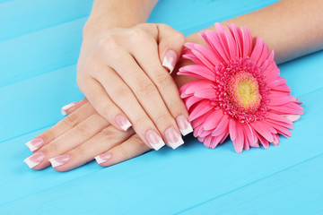 Woman hands with french manicure and flower