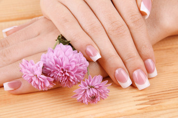 Woman hands with french manicure and flowers