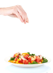 Hand adding salt isolated on white