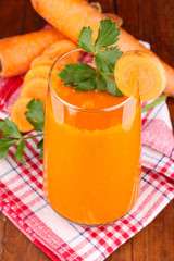 Glass of carrot juice on wooden table