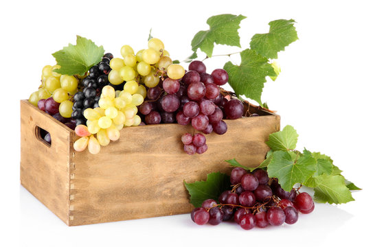 assortment of ripe sweet grapes in wooden crate, isolated