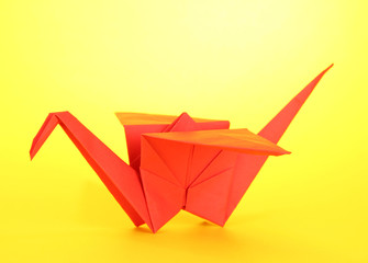 Naklejka premium Origami crane on yellow background.