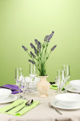 Table setting in violet and green tones on color  background