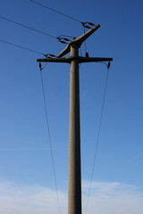 large transmission power pole, with blue sky background