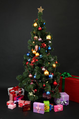Fototapeta na wymiar Decorated Christmas tree with gifts isolated on black